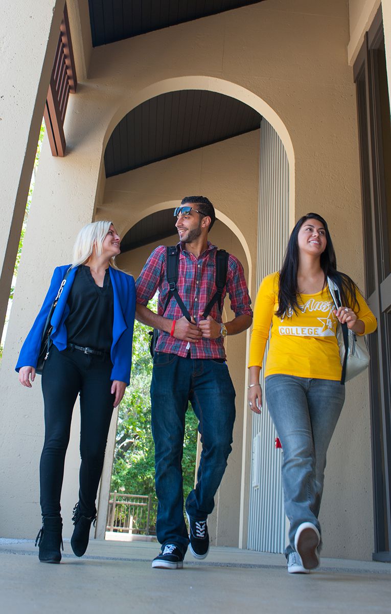 students walking under an archway