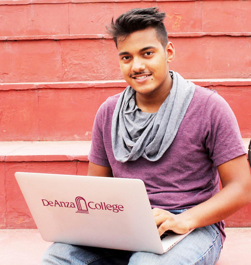 smiling student with De Anza laptop