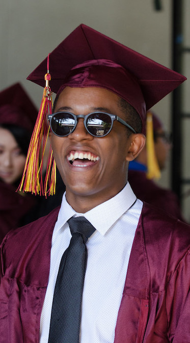 smiling grad in sunglasses