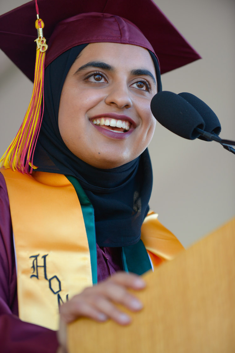 young woman in grad cap at podium