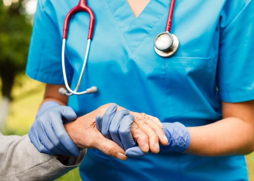 nurse holding patient's hand