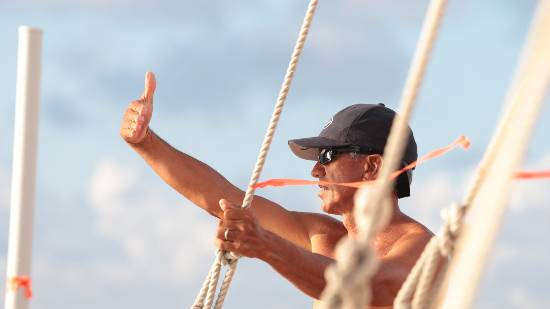 Nainoa Thompson measuring angles with horizon using his hand. Nainoa Thomposon using his had to anthropically measure the angles between the stars and horizon