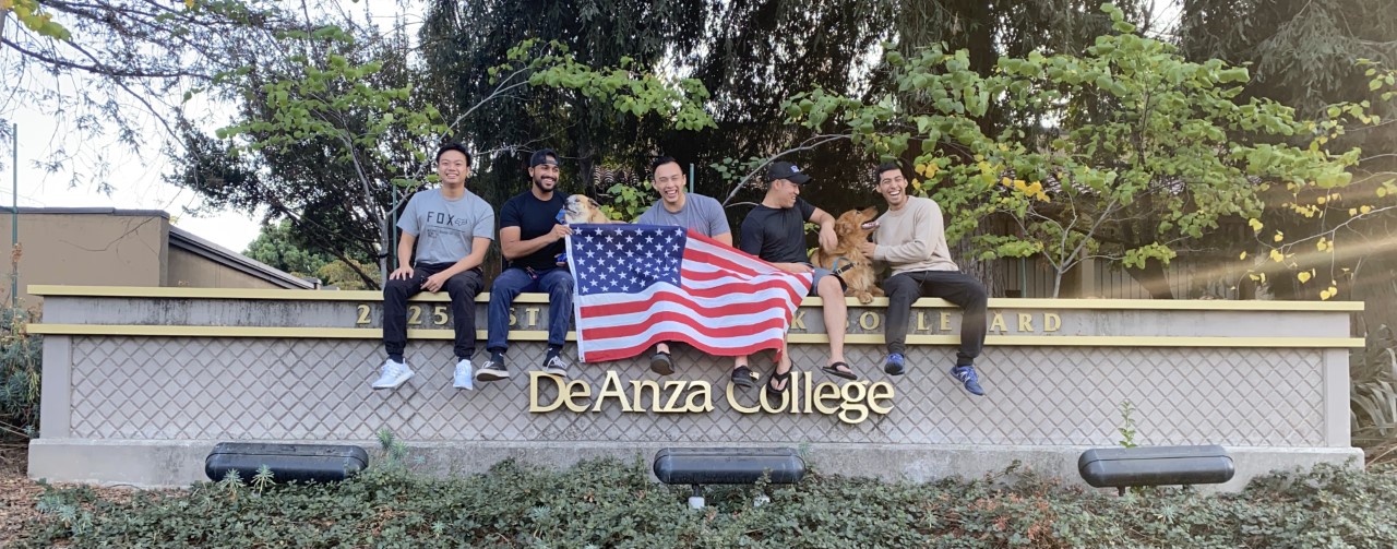 student veterans at De Anza sign with flag